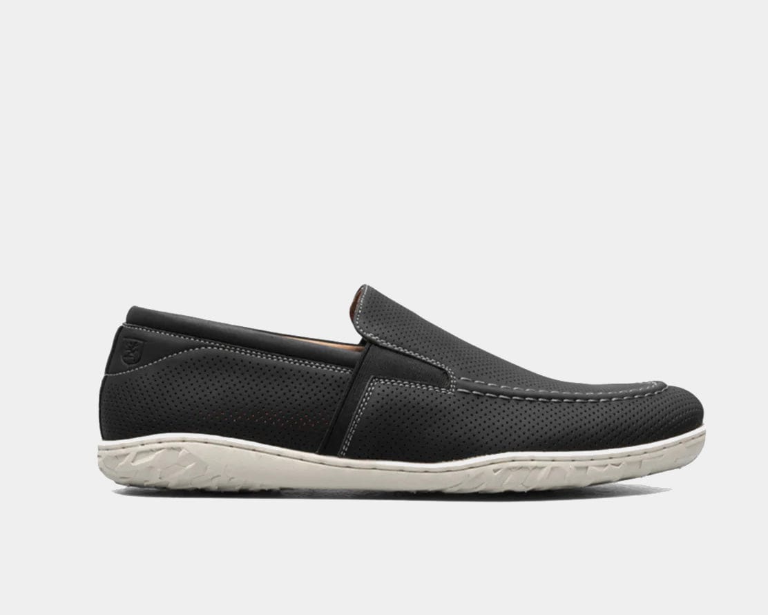 A Perforated Moc Toe Slip-On shoe in black color with a micro-perfed upper and a modern, molded sole.