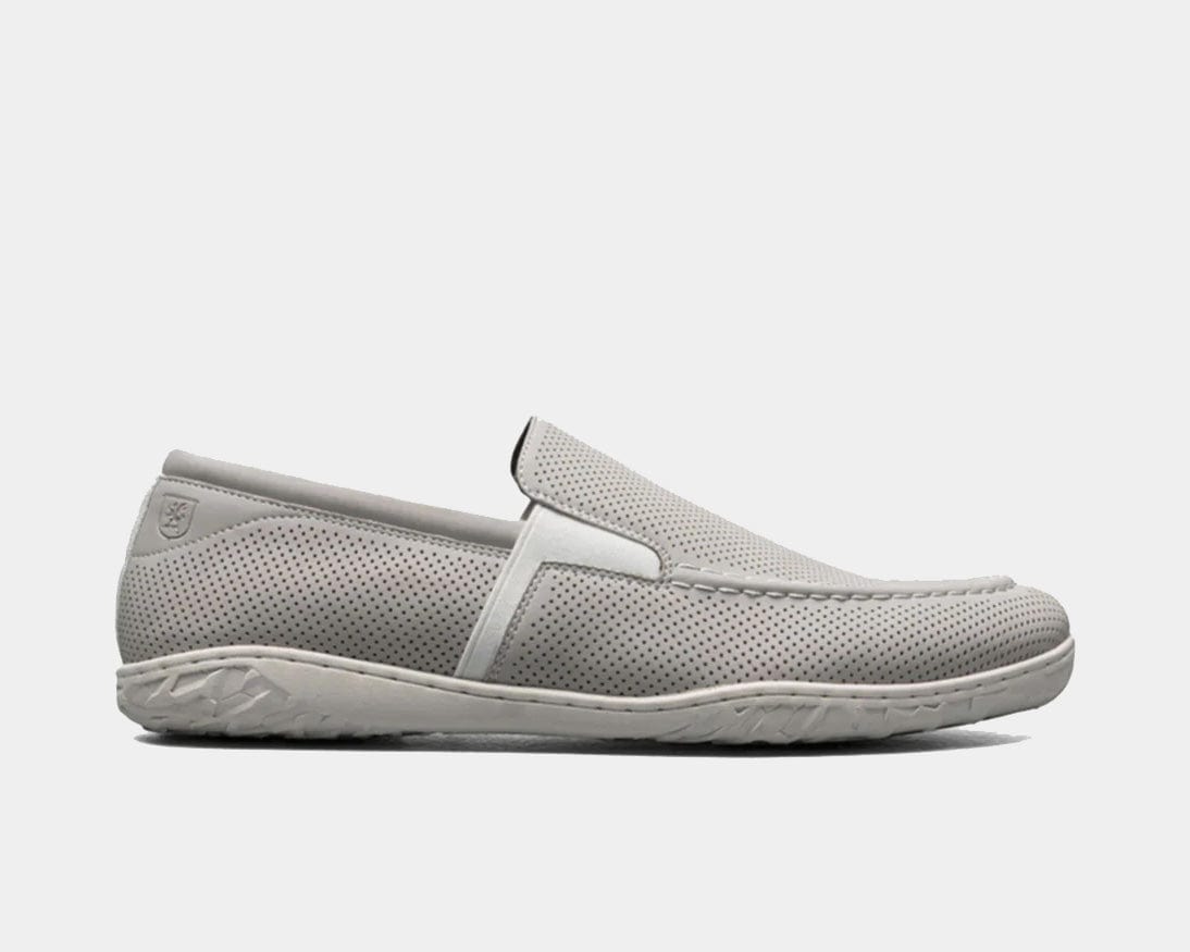 A Perforated Moc Toe Slip-On shoe in white color with a micro-perfed upper and a modern, molded sole.