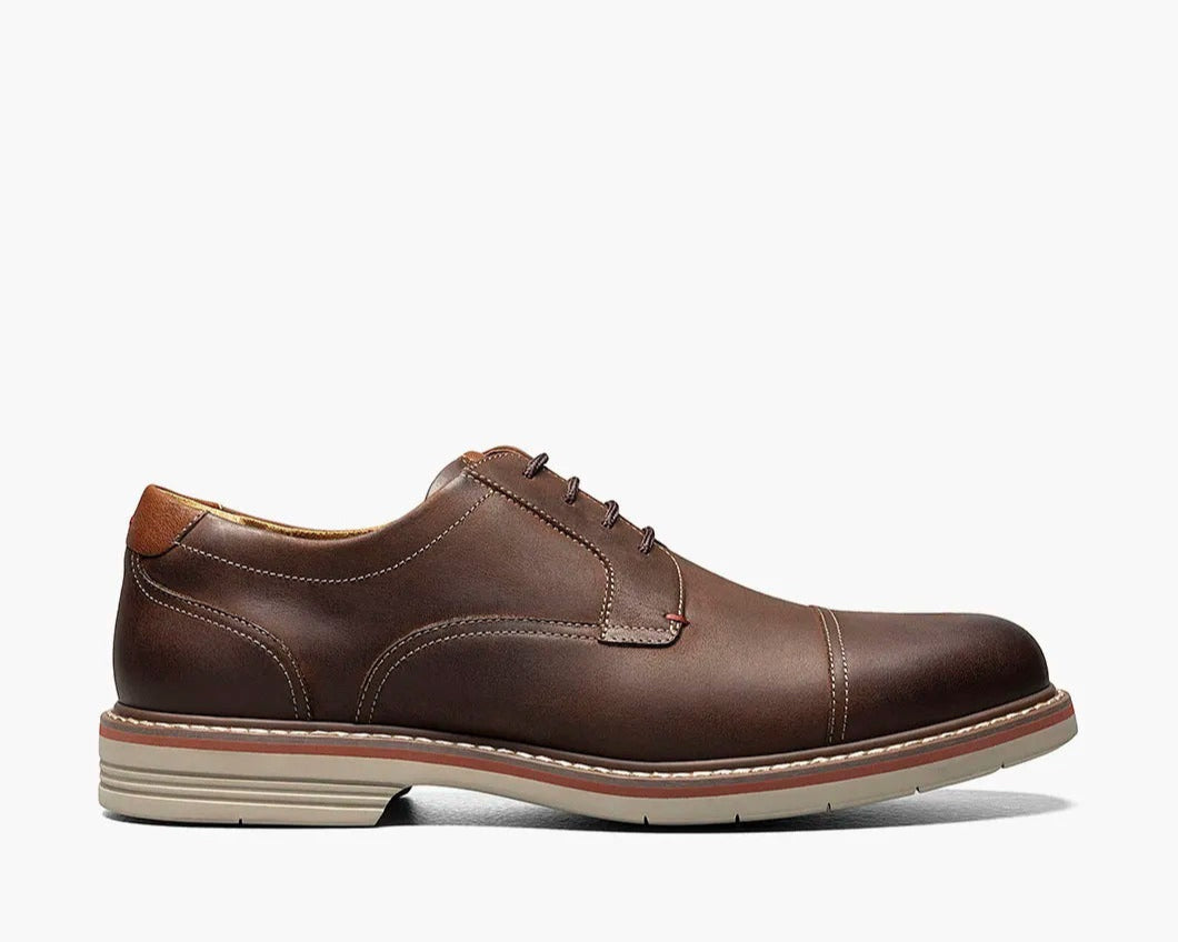 A brown Cap Toe Oxford shoe with a two-tone welt and lace-up closure.