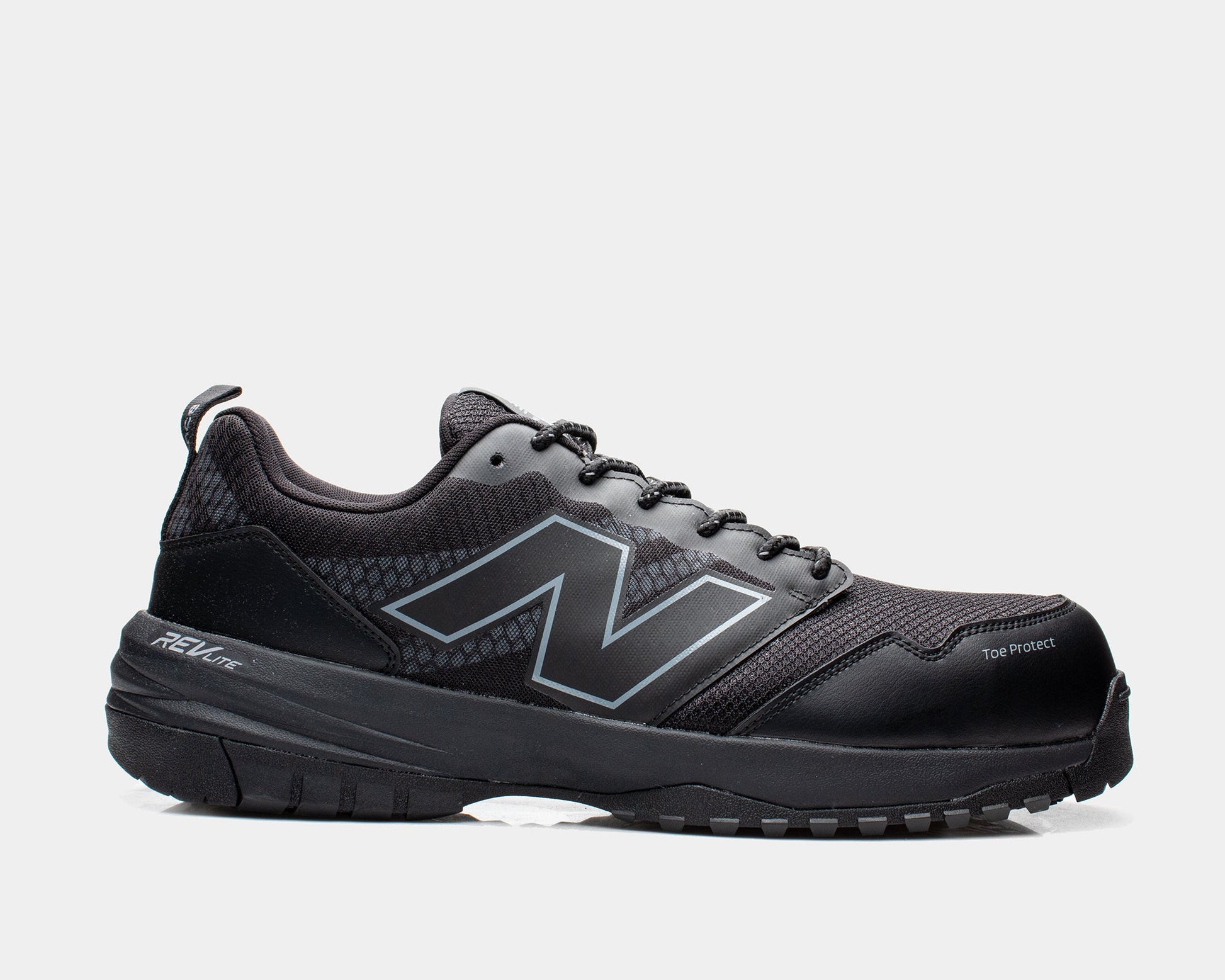 A black New Balance safety shoe with lace-up closure, featuring a composite toe and slip-resistant outsole.