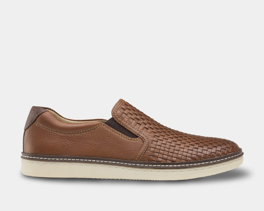 A brown woven slip-on shoe with a leather upper and a white sole.