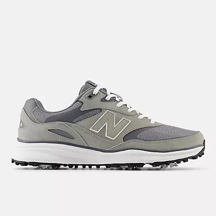 A pair of New Balance golf shoes with a grey upper and white sole, featuring replaceable cleats.